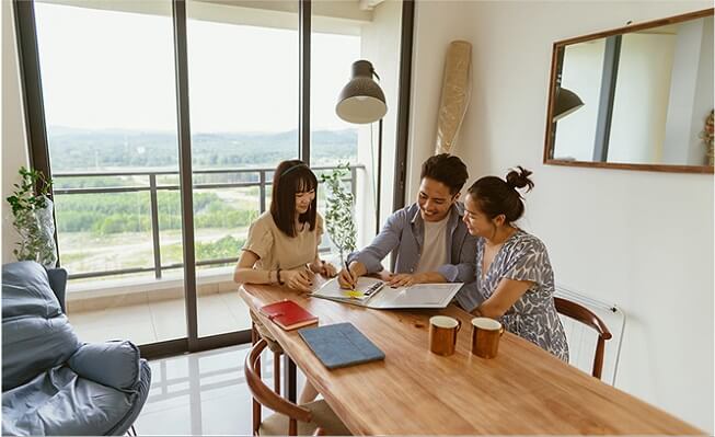 A man and woman reviewing documents at their dining table.