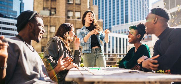 A weekend getaway with Group of five people talking outside on a rooftop.